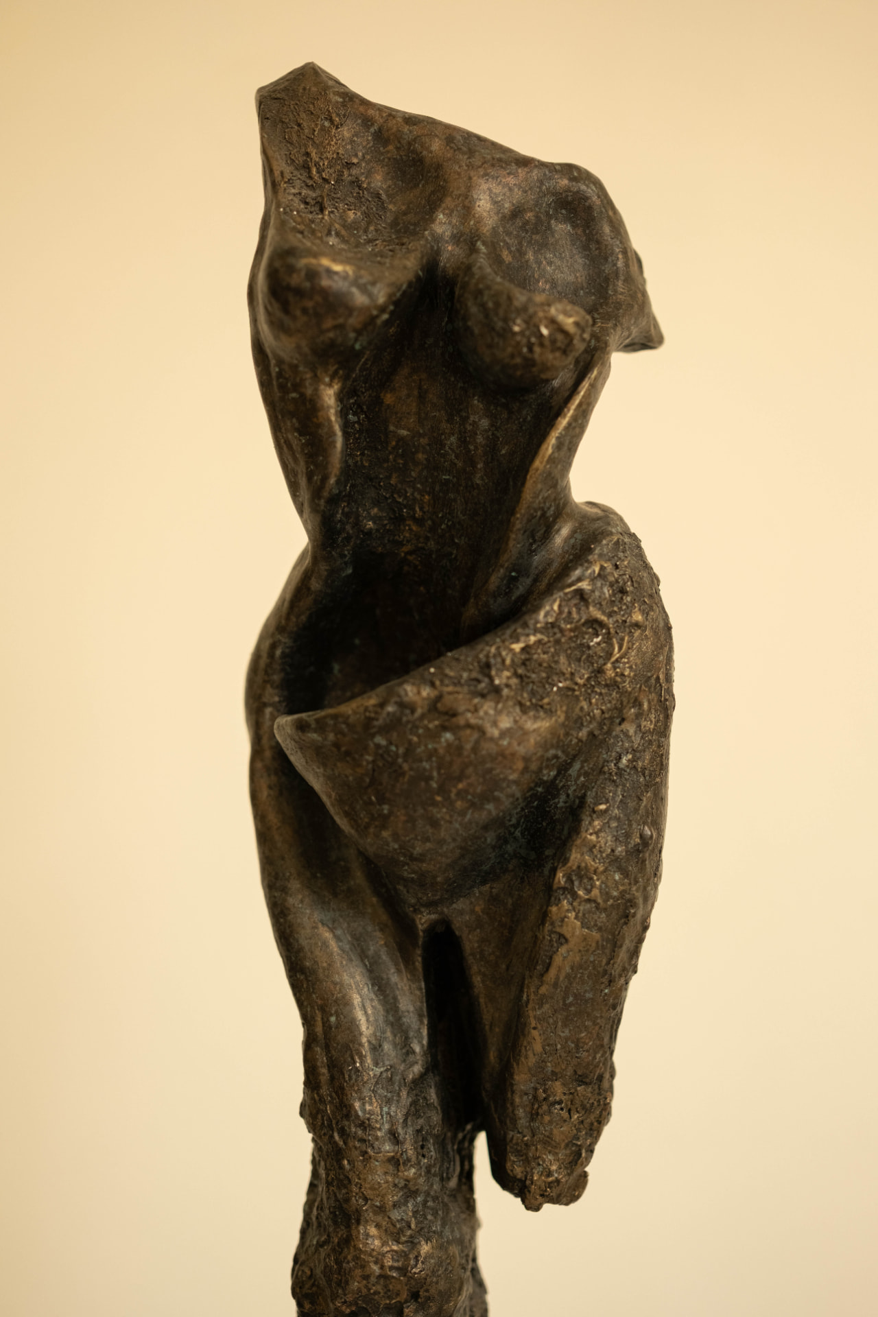 Sentinel — elongated bronze figure on a dark stone base