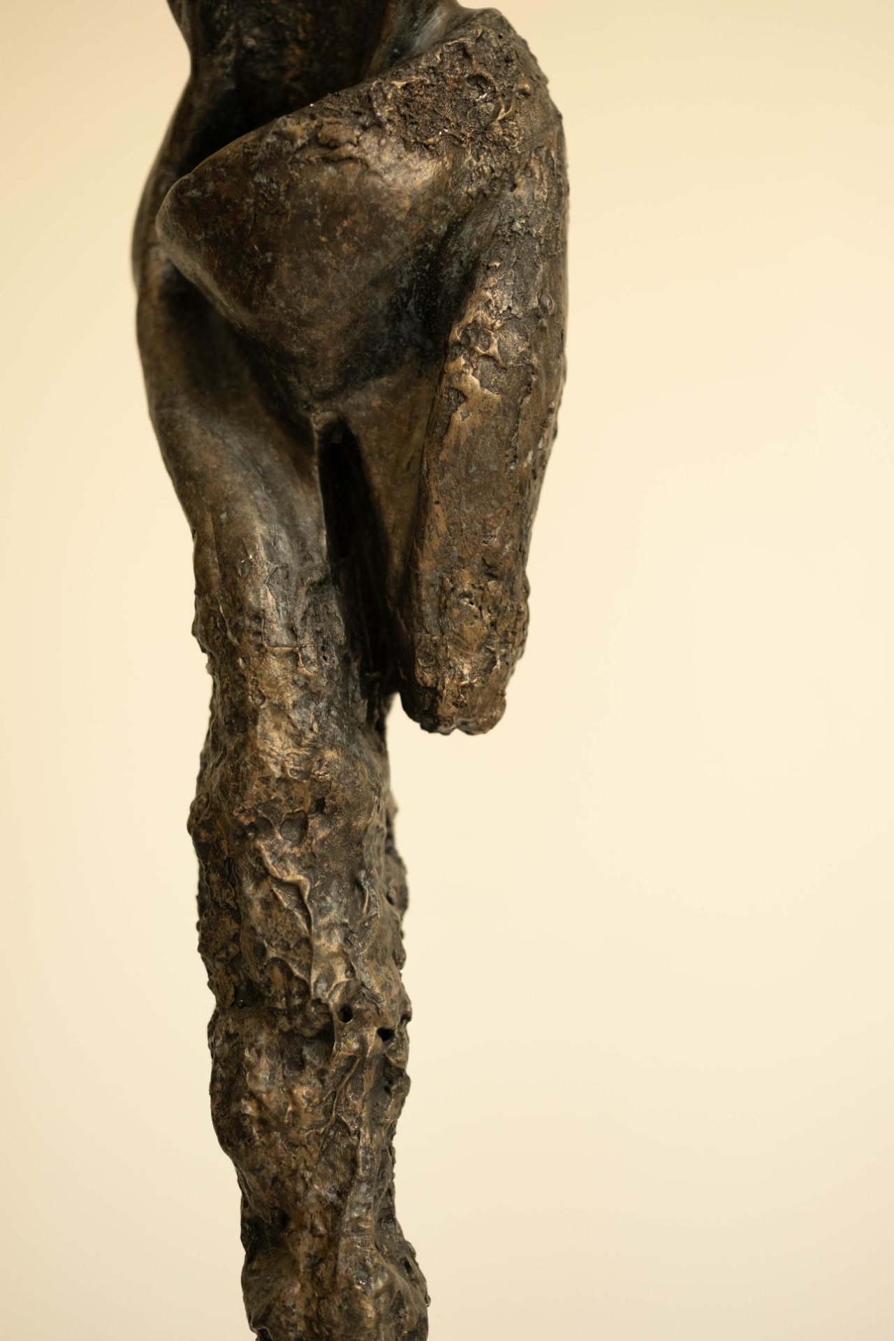 Sentinel — elongated bronze figure on a dark stone base