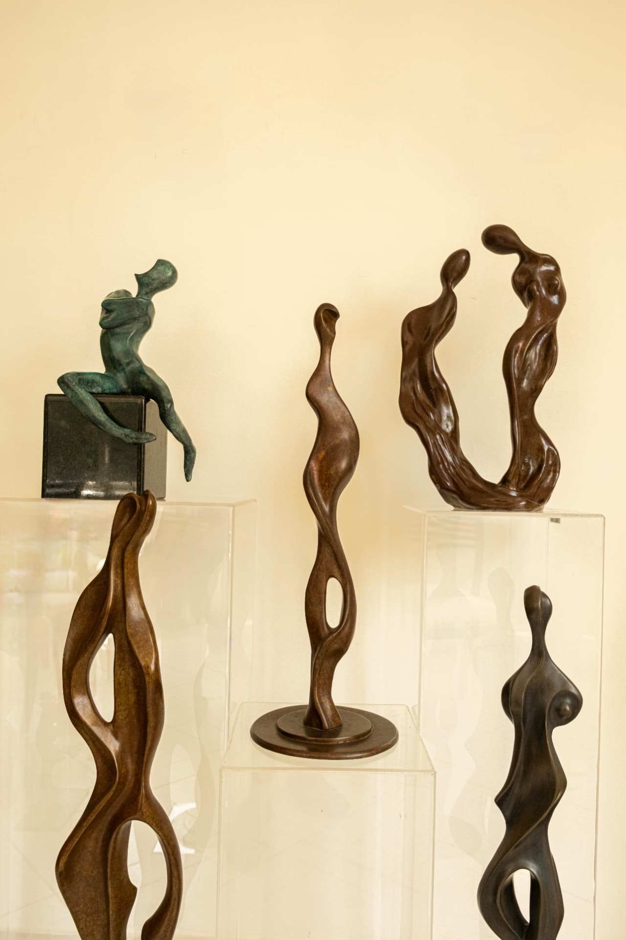 Bronze figure sculptures arranged at varying heights in the studio