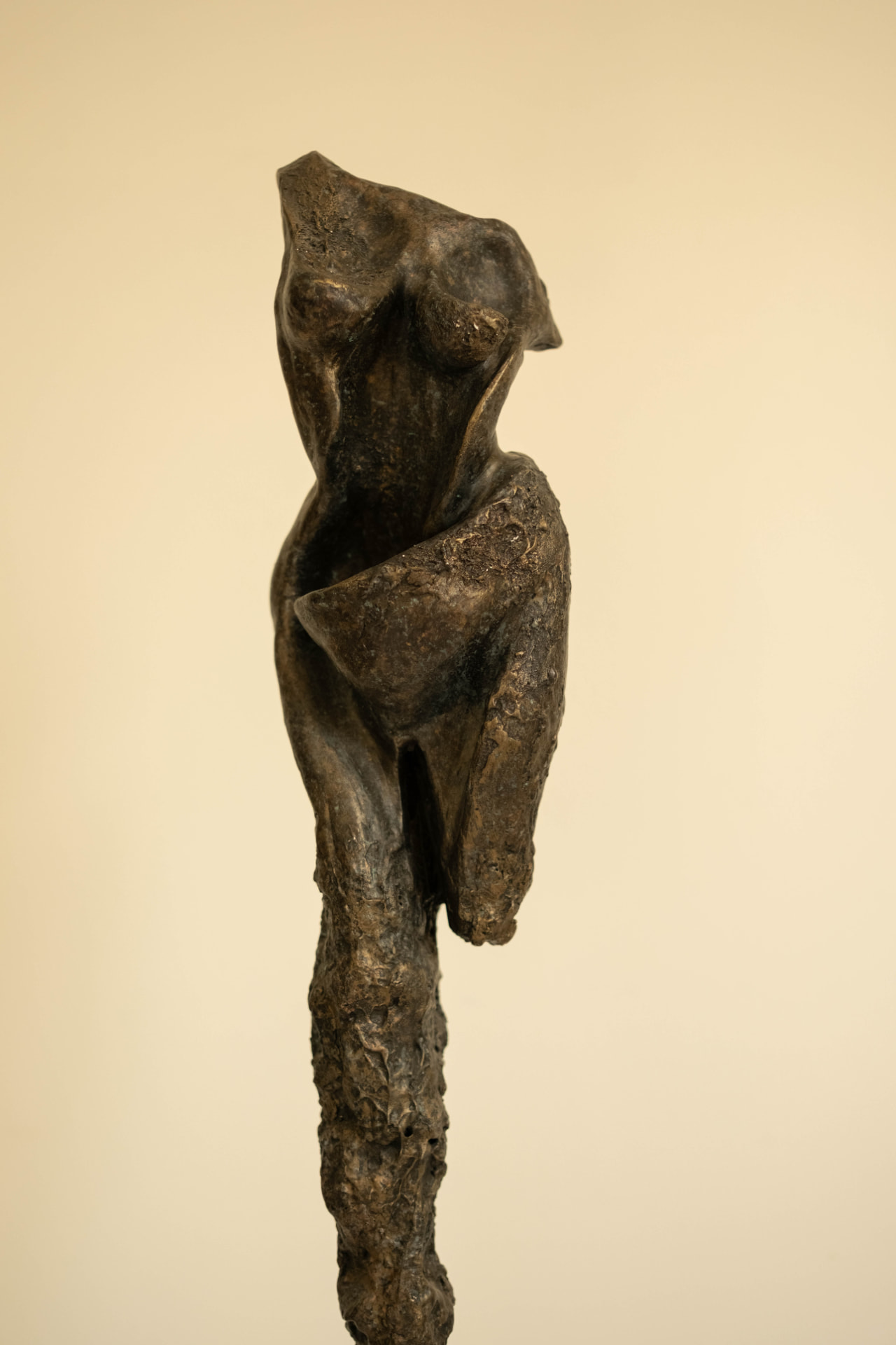 Sentinel — elongated bronze figure on a dark stone base